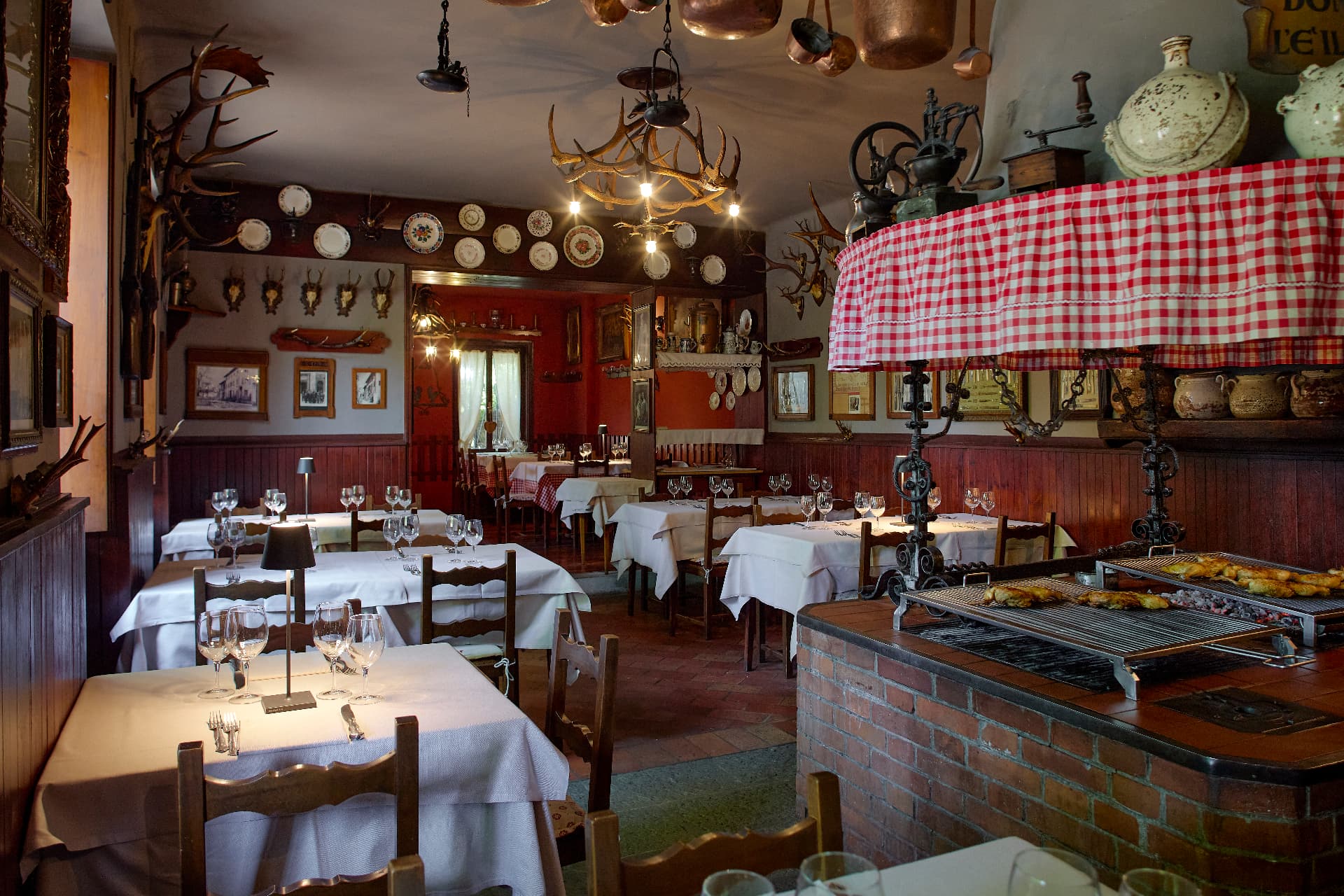 Sala d'epoca con rame appeso, trofei e brace accesa