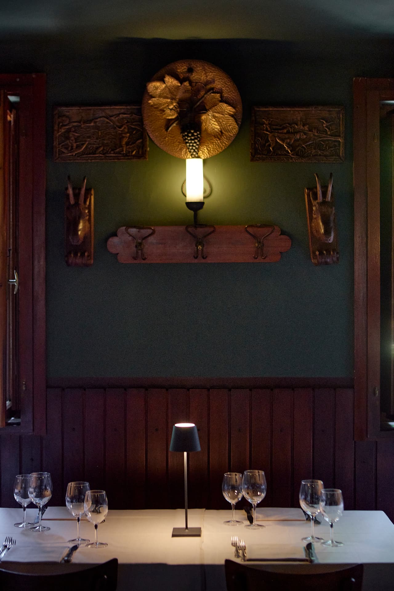 Dettaglio della sala verde con tavola apparecchiata e lampada